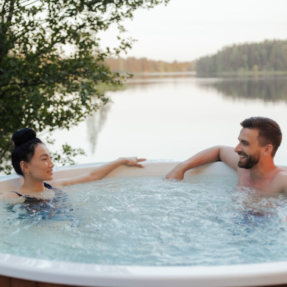 Couple relaxing in a hot tub overlooking a peaceful waterfront setting in North Carolina